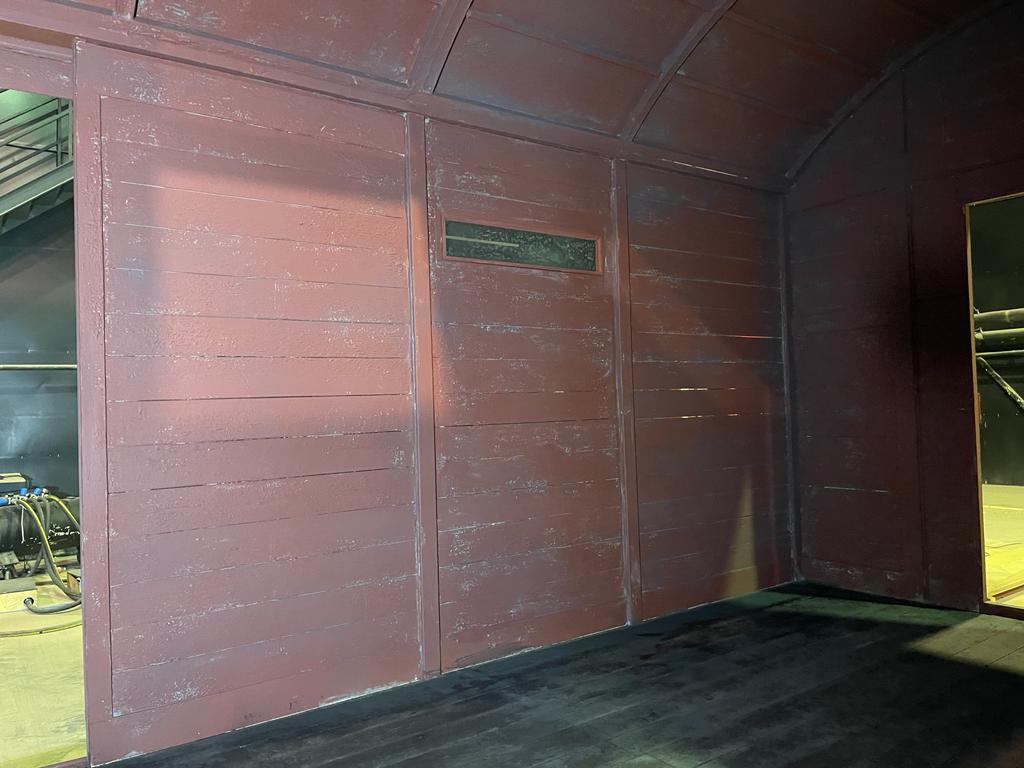 Una habitación oscura con una pared roja y un suelo negro