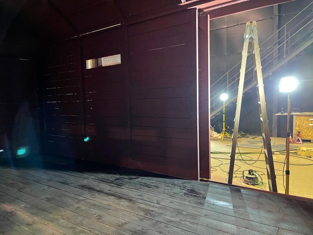 Una escalera cuelga del costado de un edificio por la noche.