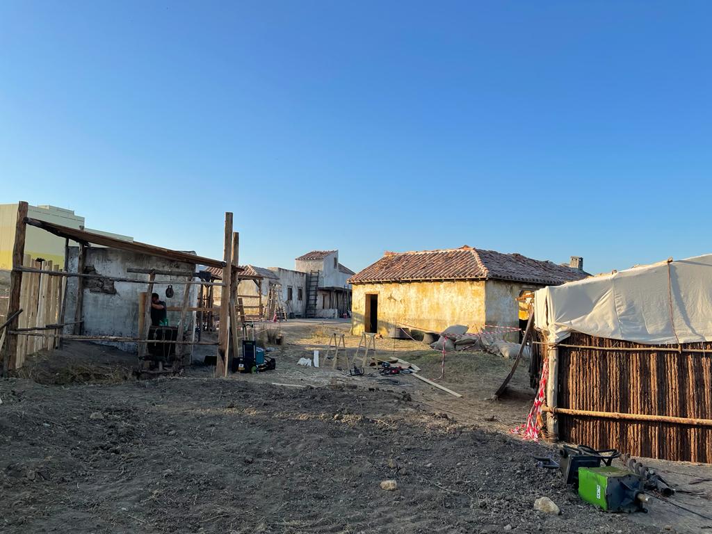 Un grupo de casas están ubicadas encima de un campo de tierra.