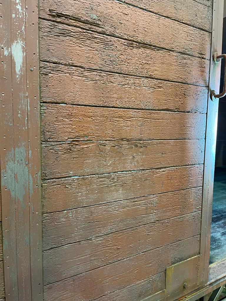 Un primer plano de una puerta de madera con pintura descascarada.