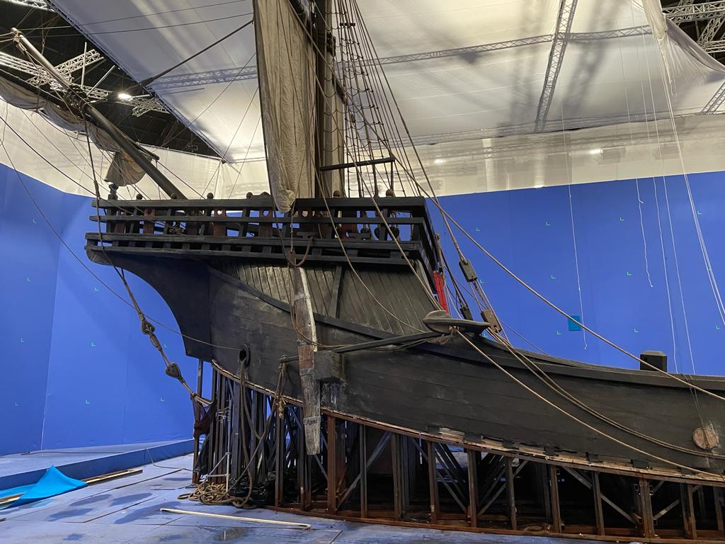 Un modelo de un barco pirata está sentado frente a una pantalla azul.