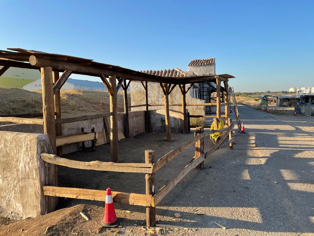Una valla de madera rodea un edificio en el desierto.