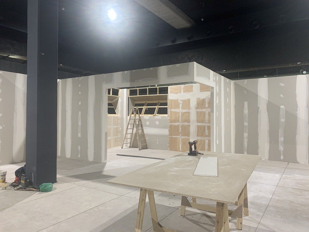 Se está remodelando una habitación con una mesa y una escalera dentro.