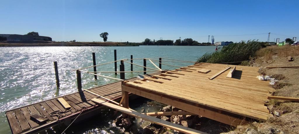 Se está construyendo un muelle de madera al lado de un cuerpo de agua.