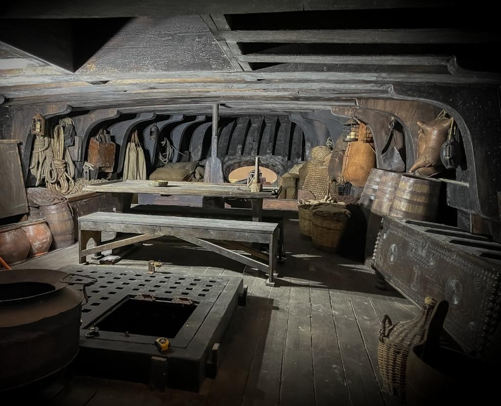 Una habitación oscura con una mesa y barriles dentro.