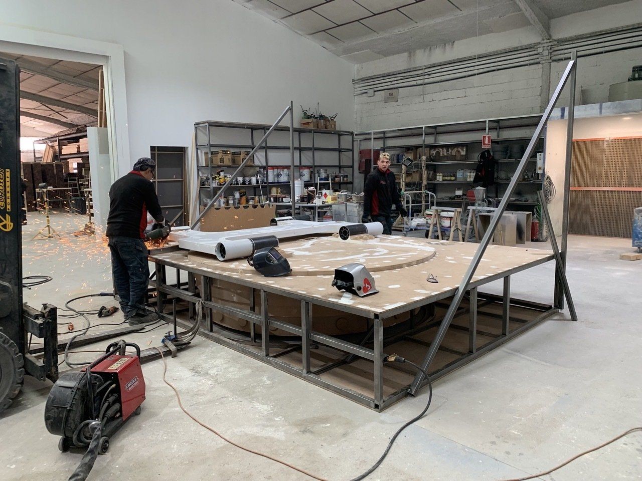 Un grupo de hombres está trabajando en un escenario en una fábrica.