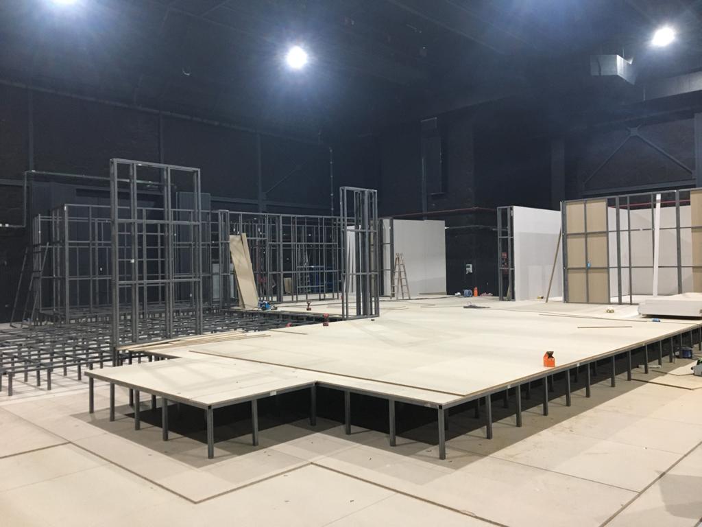 Una gran sala vacía con un escenario en el medio.