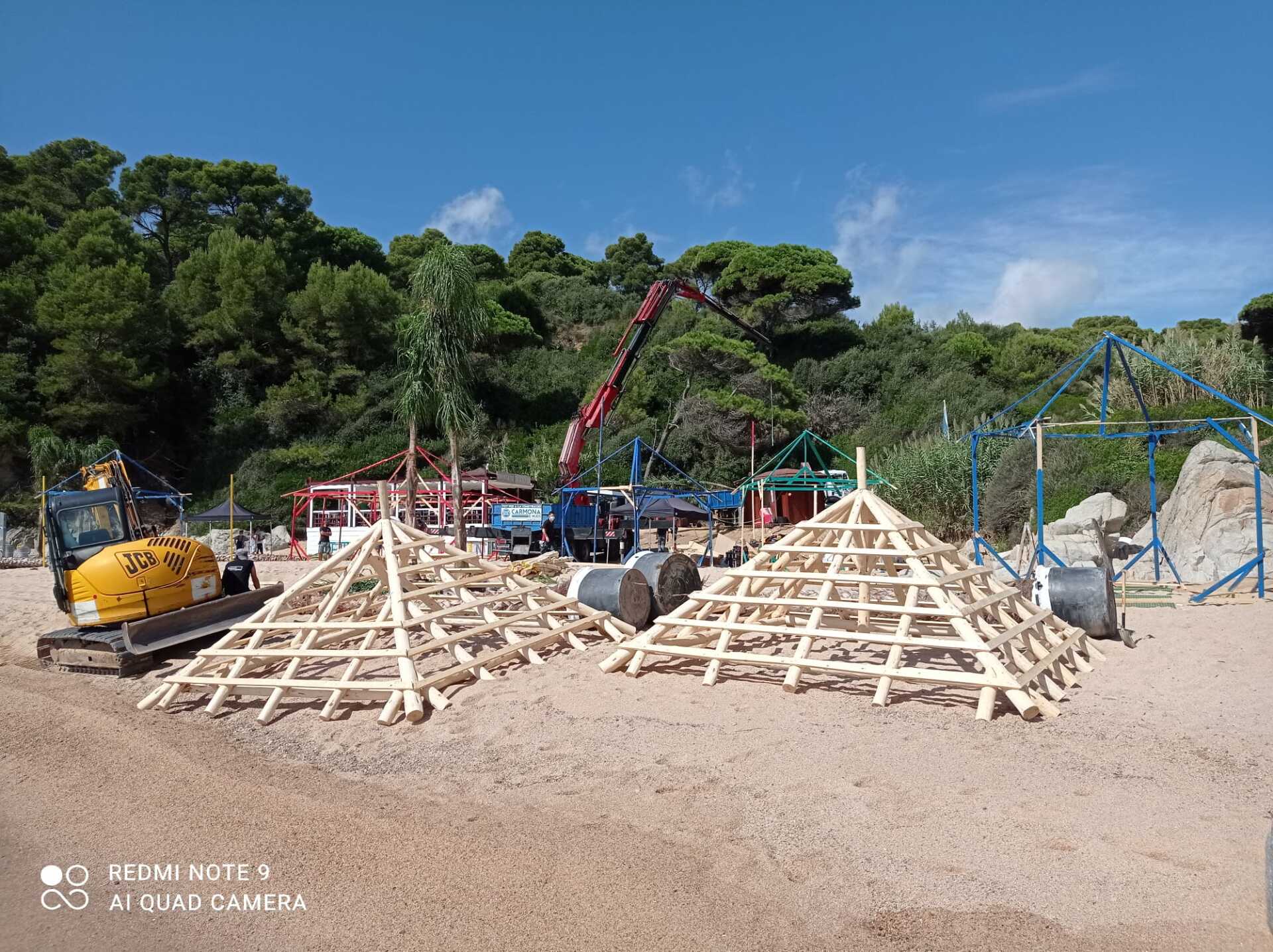 Se está utilizando una grúa para construir una estructura de madera en una playa.