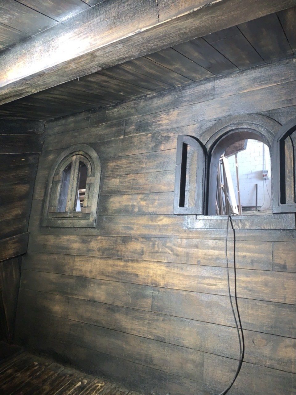 Una pared de madera con dos ventanas.