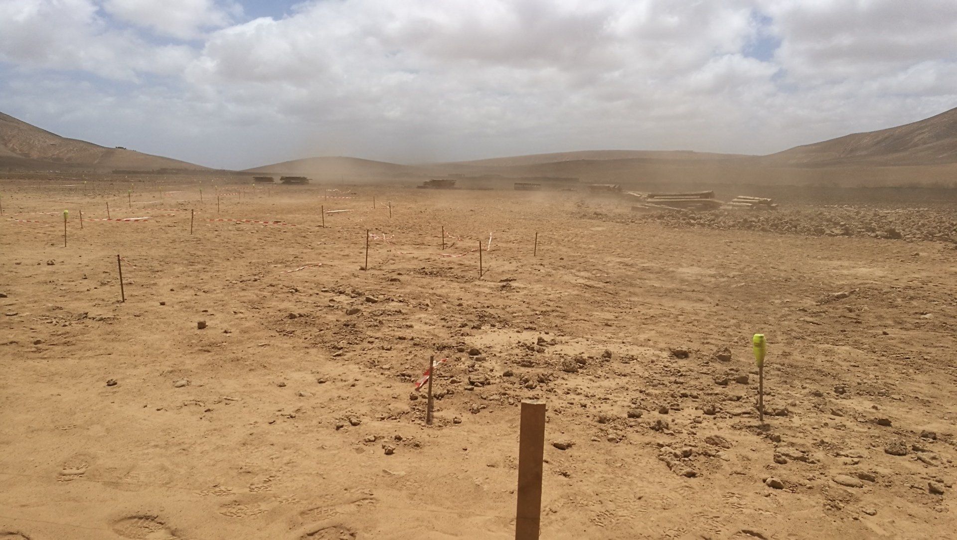 Un paisaje desértico con un poste de madera en el medio.