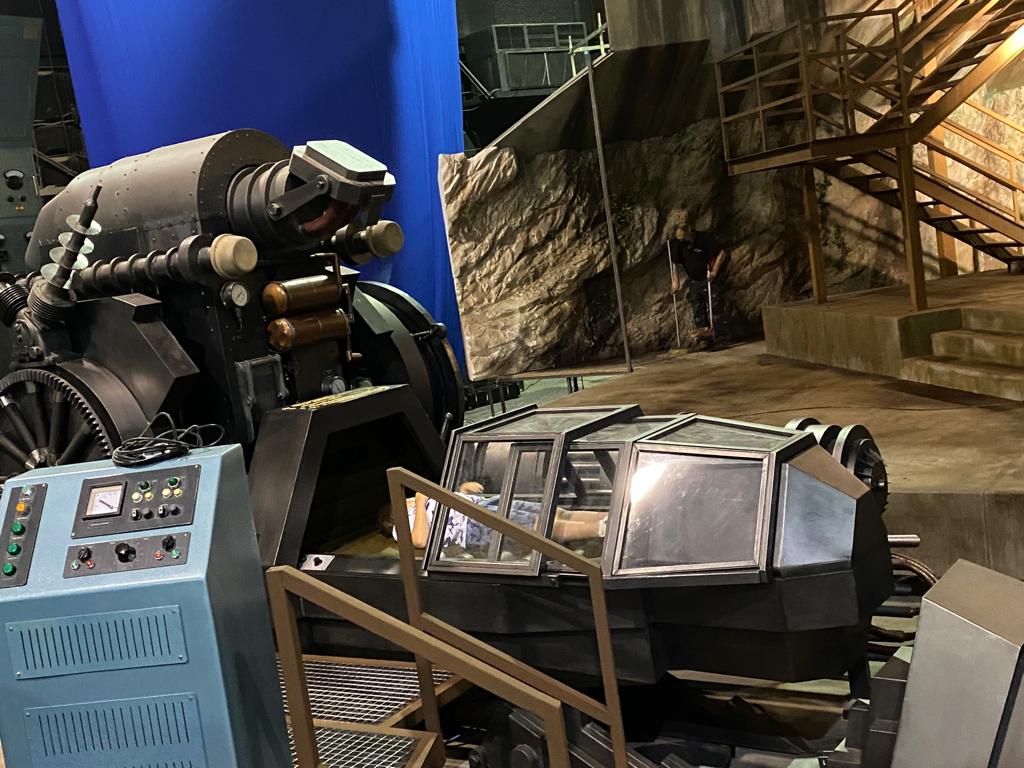 Una máquina está sentada en una habitación con escaleras al fondo.