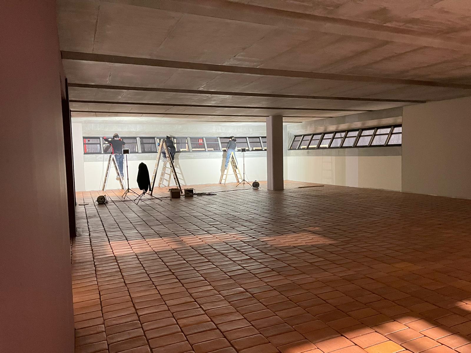 Una gran habitación vacía con suelo de baldosas y una escalera.