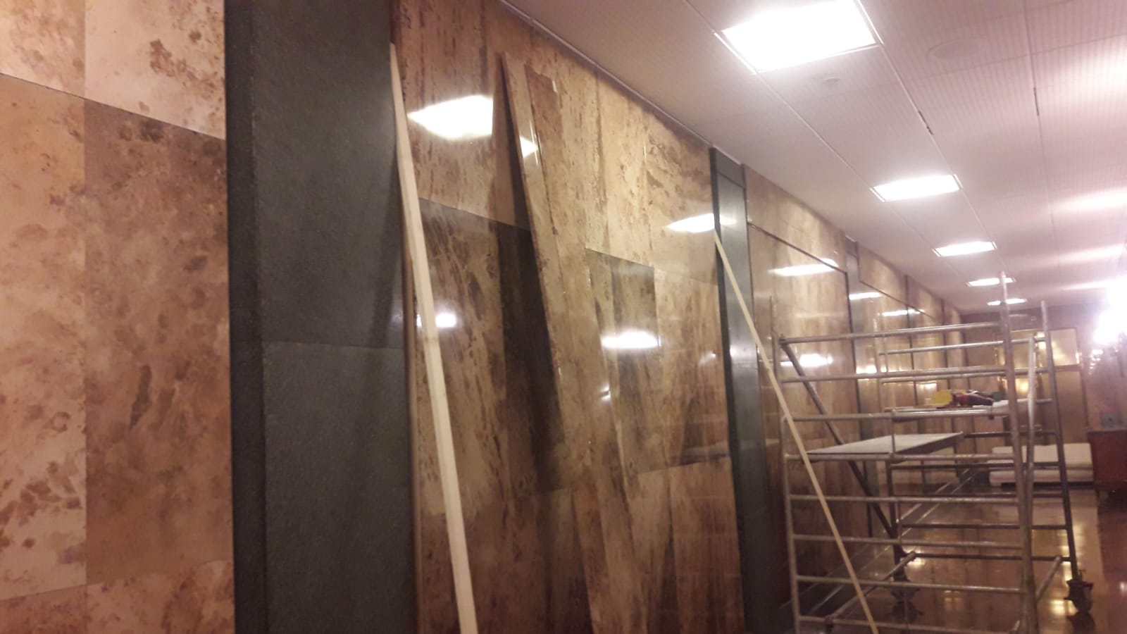 Un largo pasillo con andamios y una gran pared.