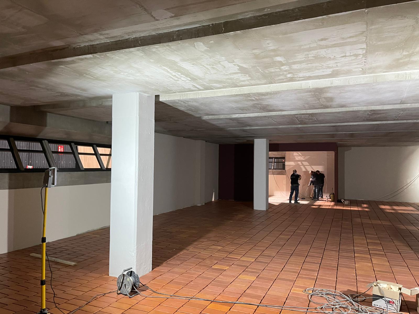 Un grupo de personas está de pie en una gran habitación vacía.