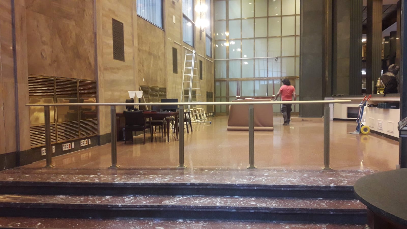 Un gran vestíbulo con escaleras y barandilla de cristal.