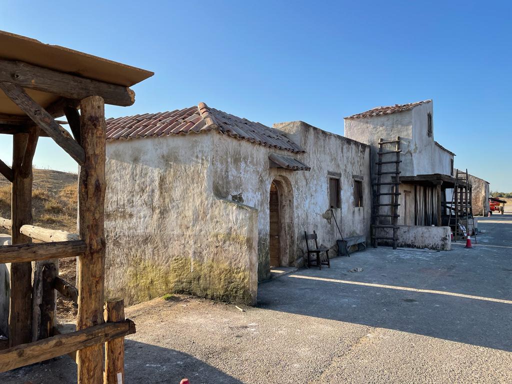 Una hilera de edificios antiguos con una valla de madera delante de ellos.