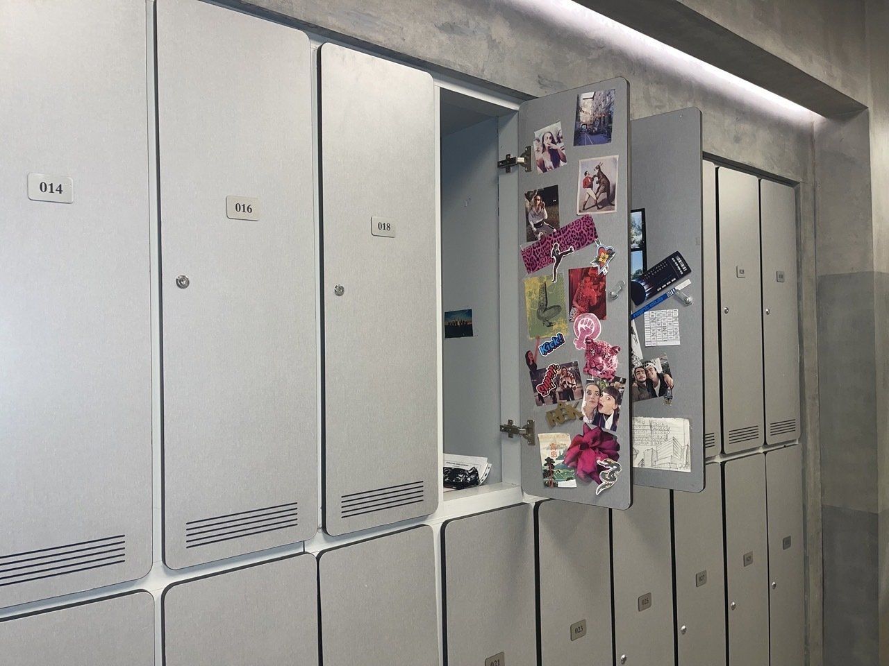 Una fila de taquillas en un vestuario con una puerta abierta.