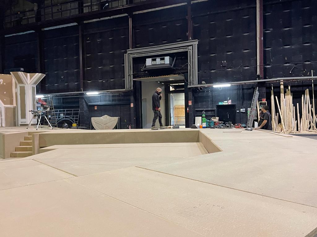 Un hombre camina en un escenario en un gran edificio.