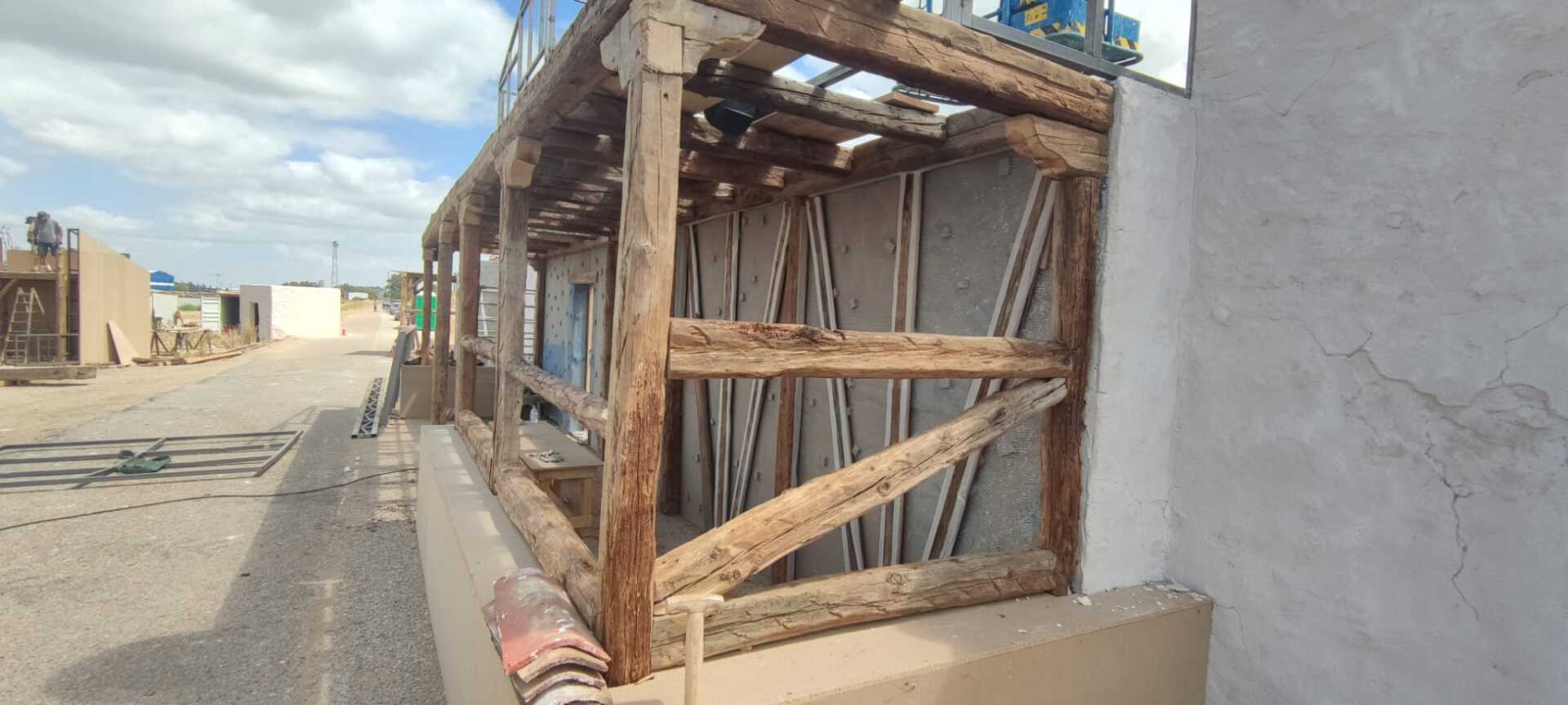 Una estructura de madera está sentada al costado de un edificio.