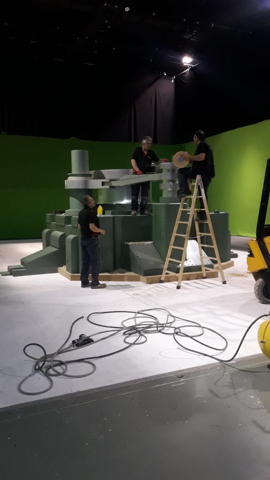 Un grupo de personas está trabajando en una pantalla verde en una habitación.