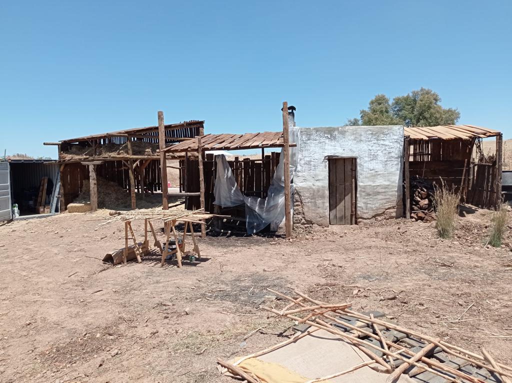 Un edificio viejo está situado en medio de un campo de tierra.