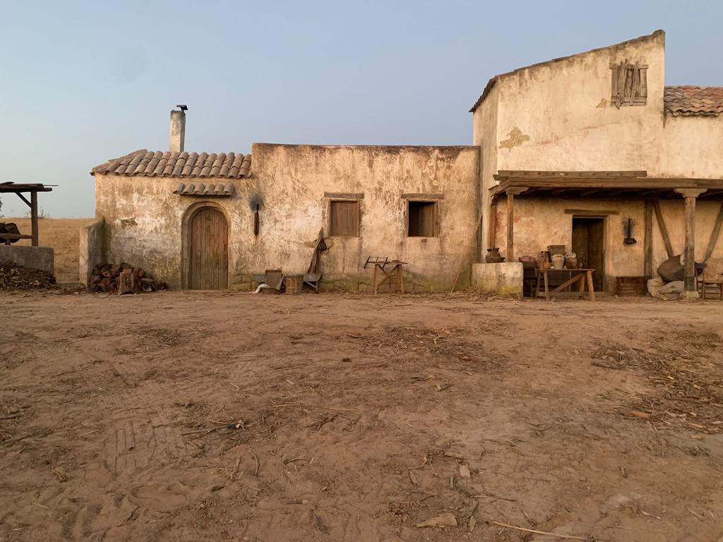 Una hilera de edificios antiguos en medio de un campo de tierra