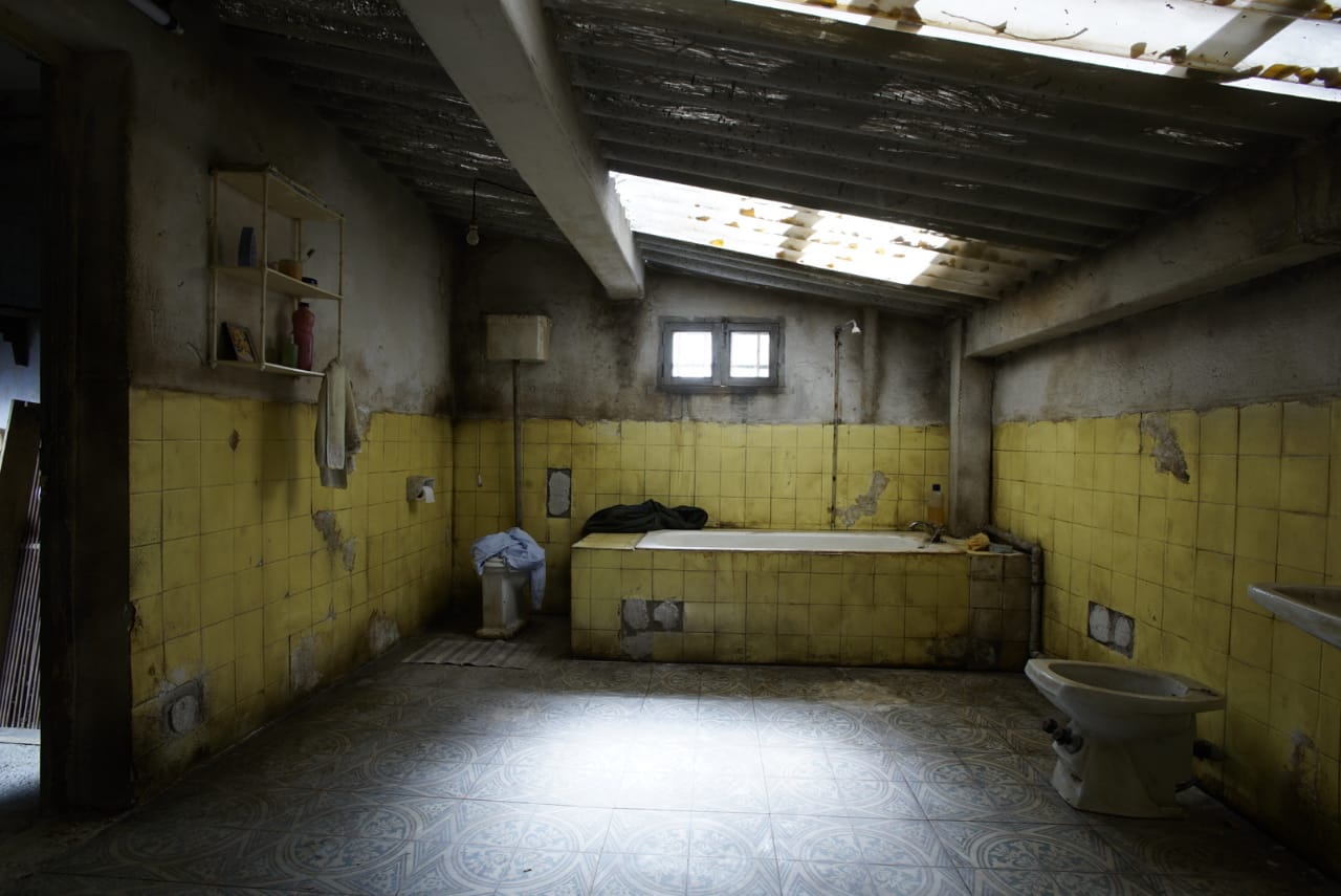 Un baño con azulejos amarillos y una bañera.