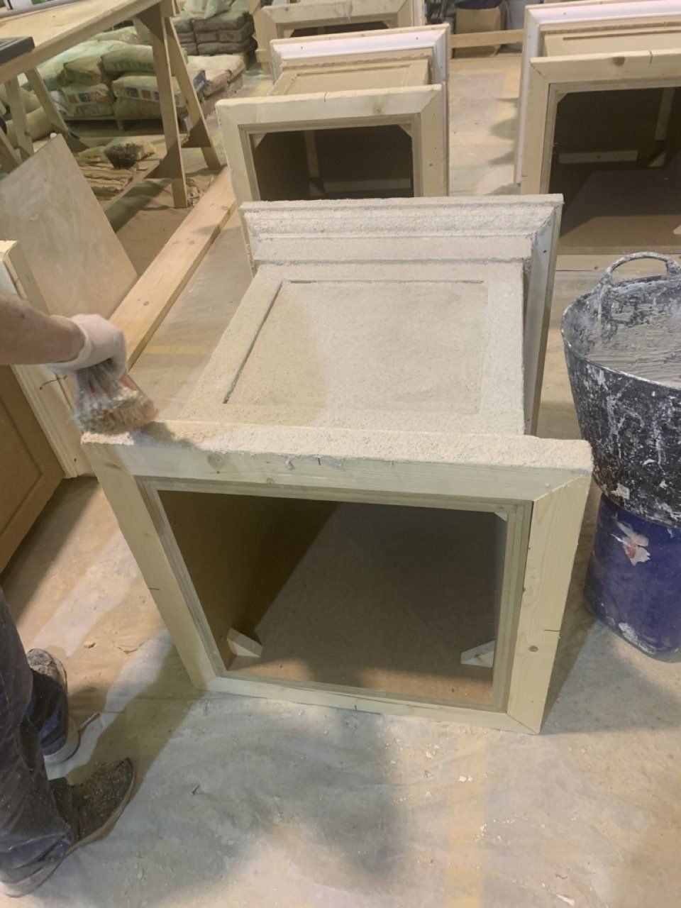 Una persona está pintando un trozo de madera en un taller.
