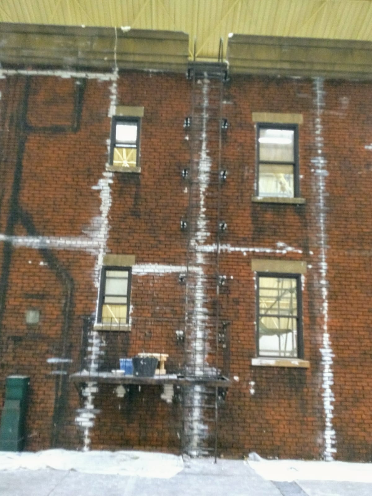 Un edificio de ladrillo con una escalera de incendios en el lateral.