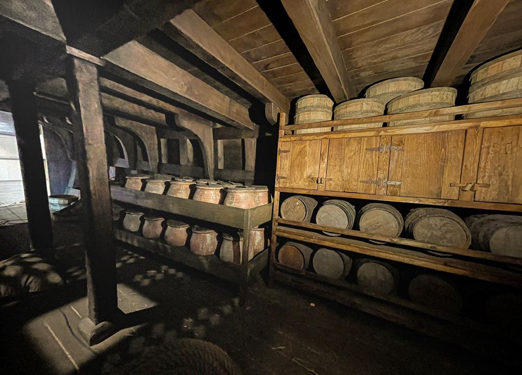 Una habitación con muchos barriles en los estantes.