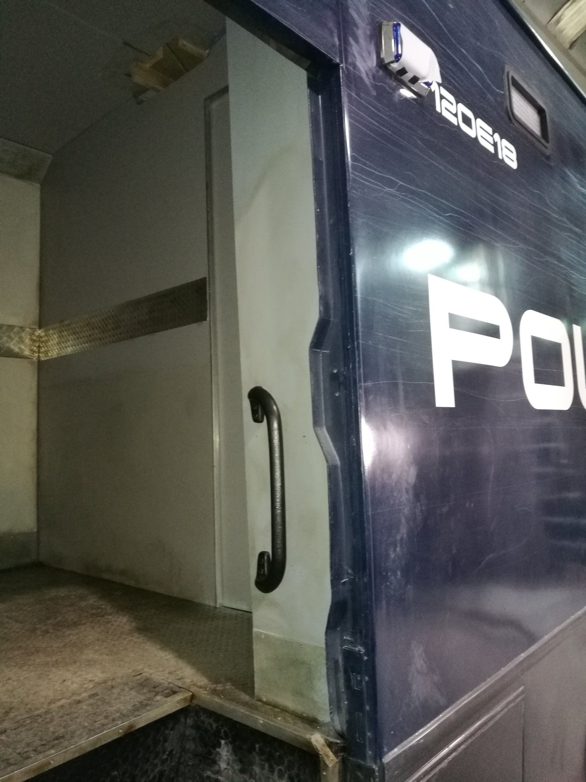 El interior de un furgón policial con la puerta abierta.