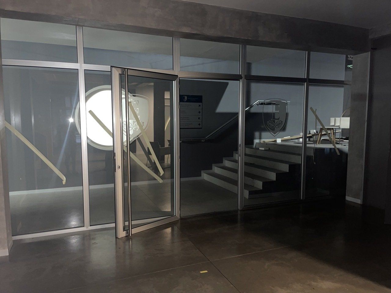 Una habitación vacía con una puerta de cristal y escaleras.