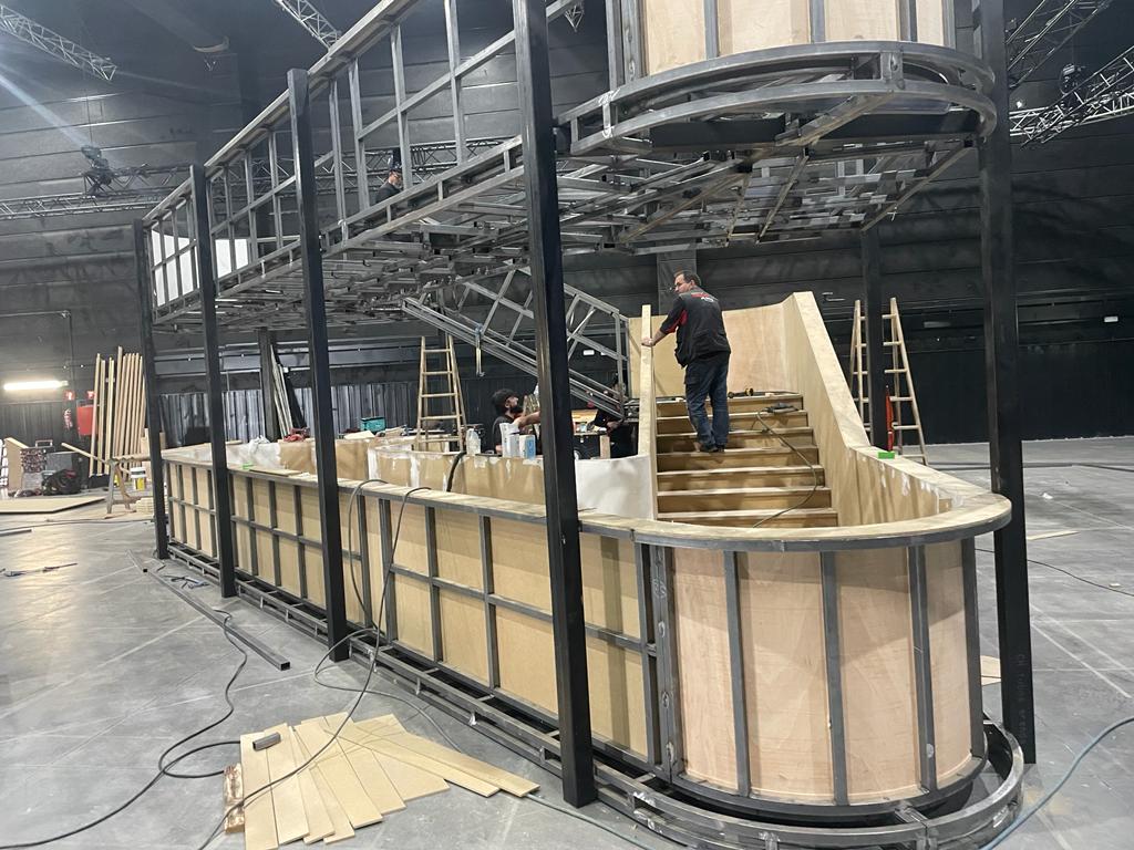 Un hombre está de pie junto a una escalera en un edificio en construcción.