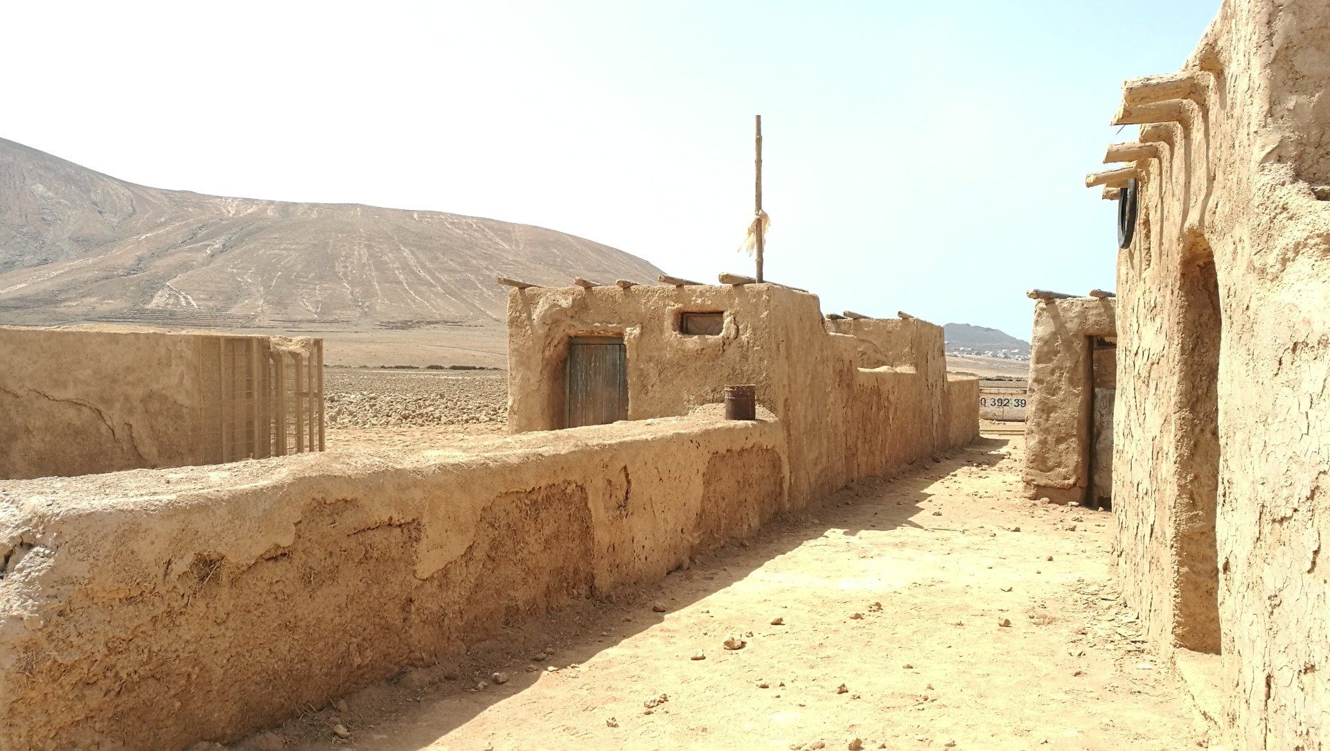 Un paisaje desértico con algunos edificios y montañas al fondo.