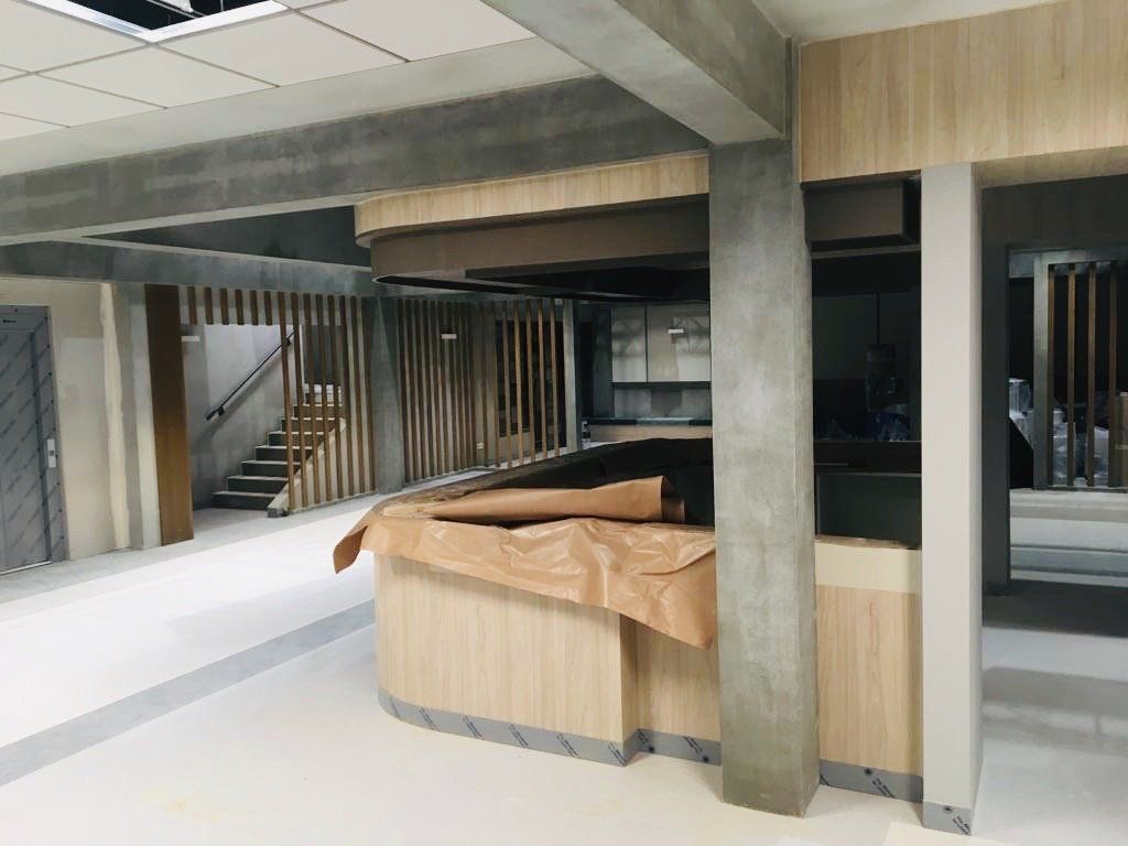 Una habitación grande con mostrador de madera y escaleras.