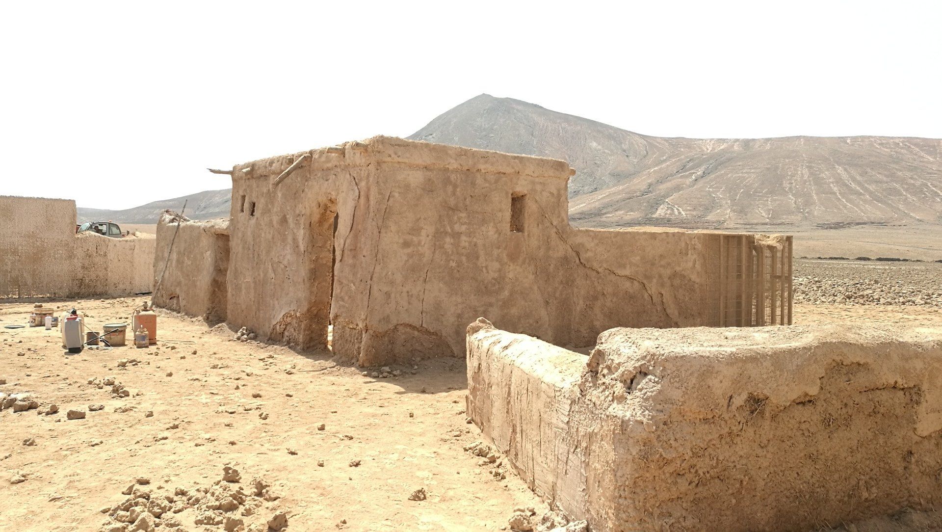 Un grupo de edificios en el desierto con montañas al fondo.
