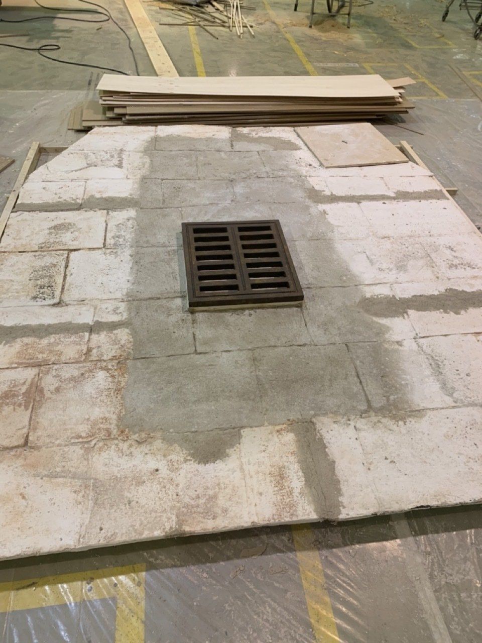 Una tapa de alcantarilla está colocada encima de un piso de concreto.