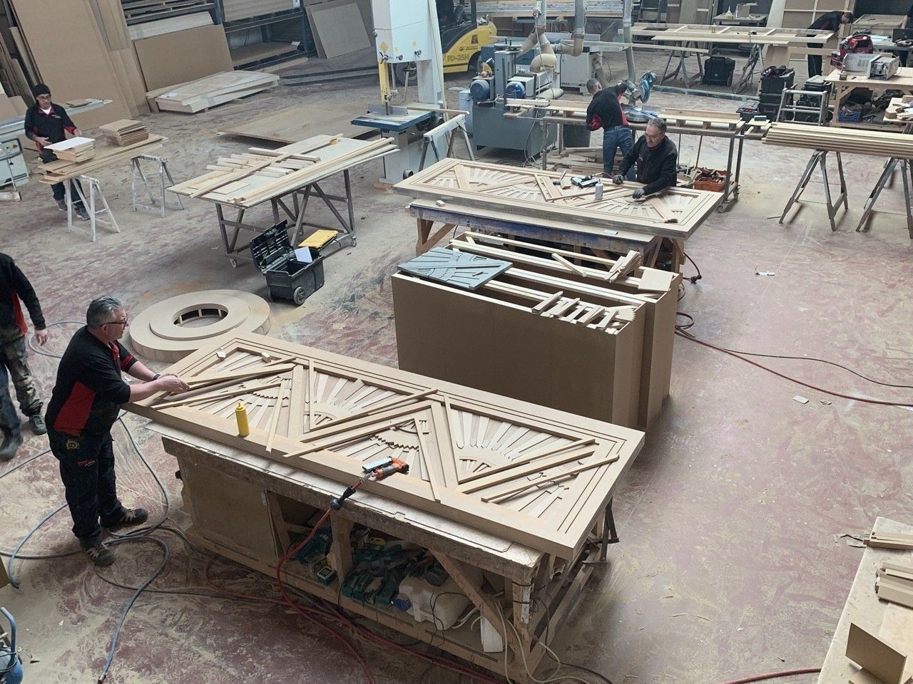 Un grupo de hombres está trabajando en un taller de carpintería.