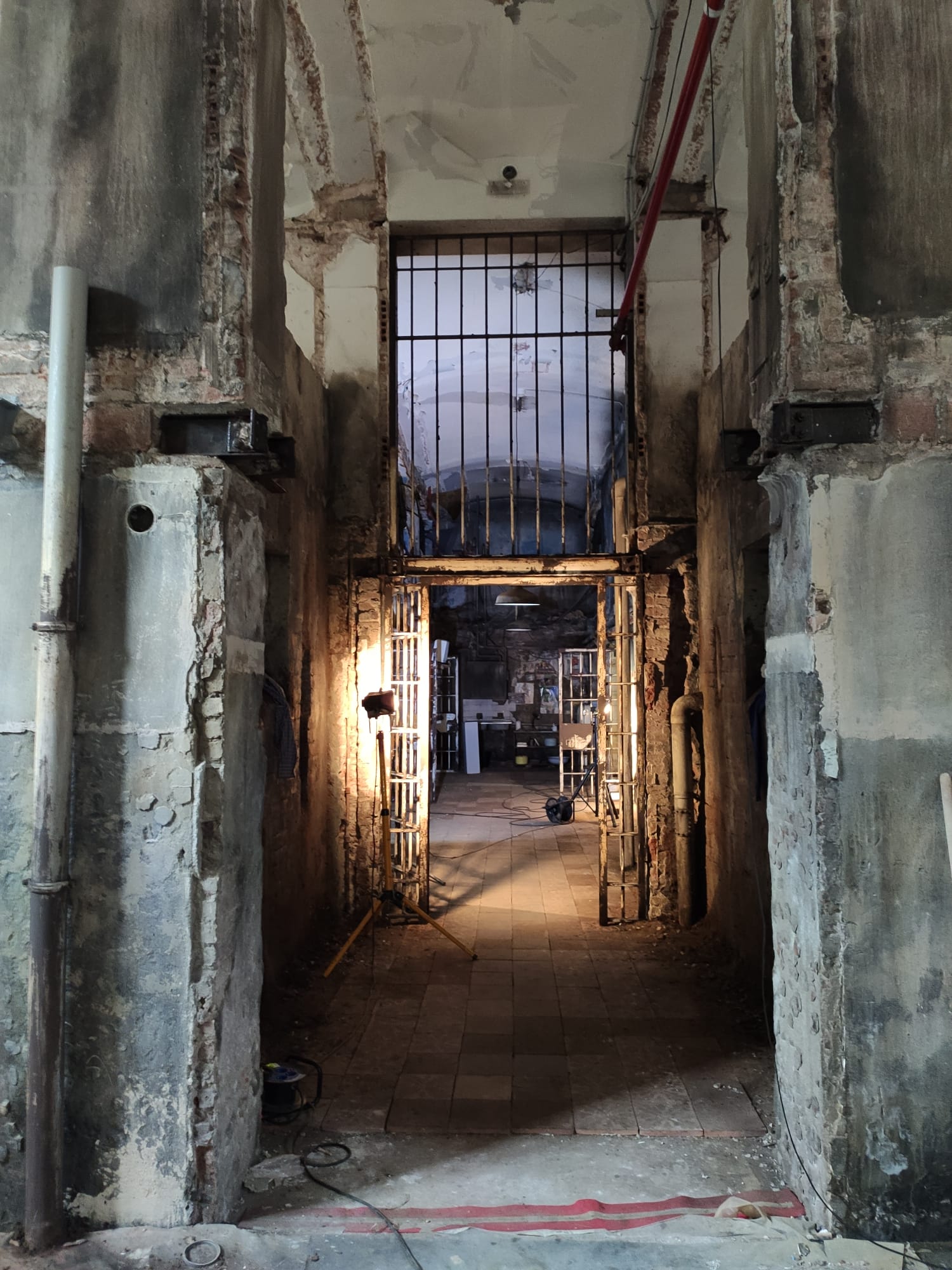 Un pasillo oscuro con una celda de prisión al fondo.