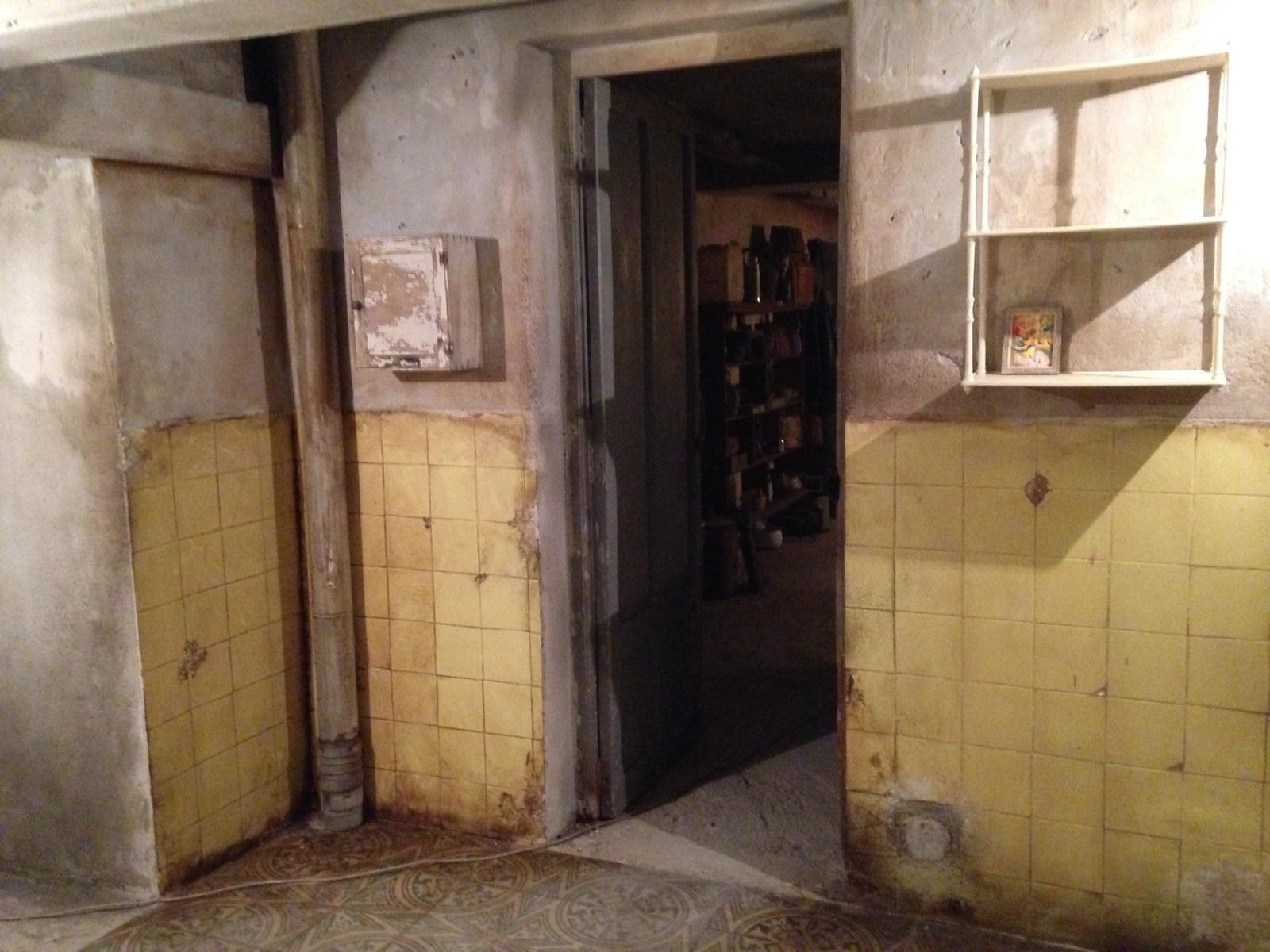 Una habitación con azulejos amarillos en las paredes y una puerta.