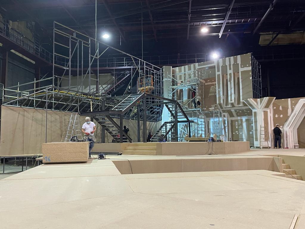 Un hombre está de pie en un escenario en un edificio en construcción.