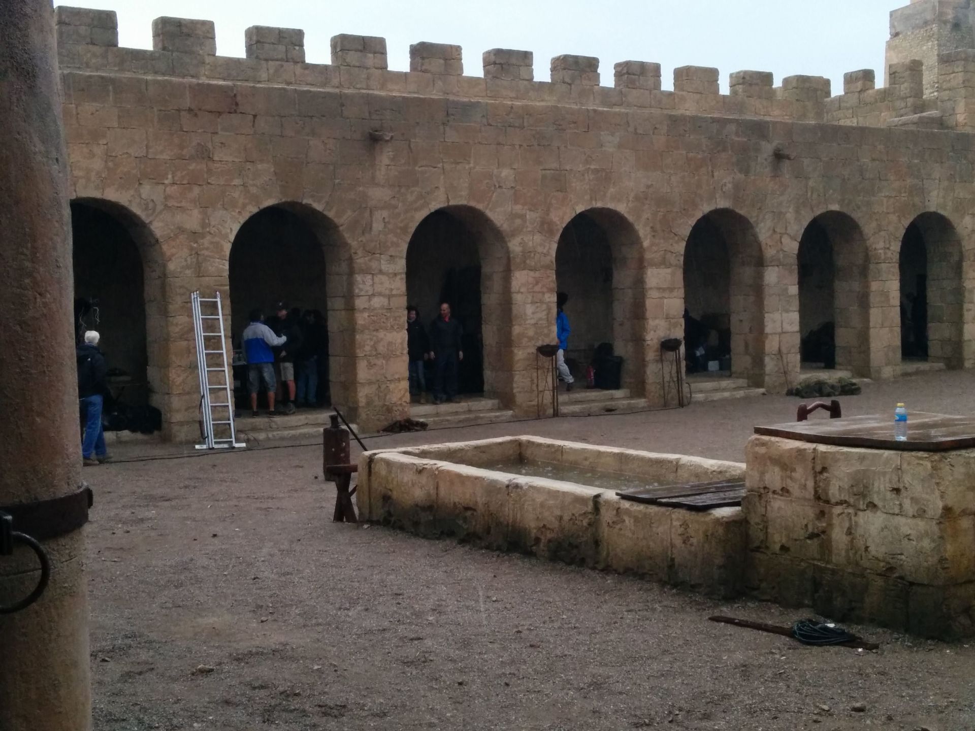 Un edificio de piedra con arcos y una escalera al fondo.