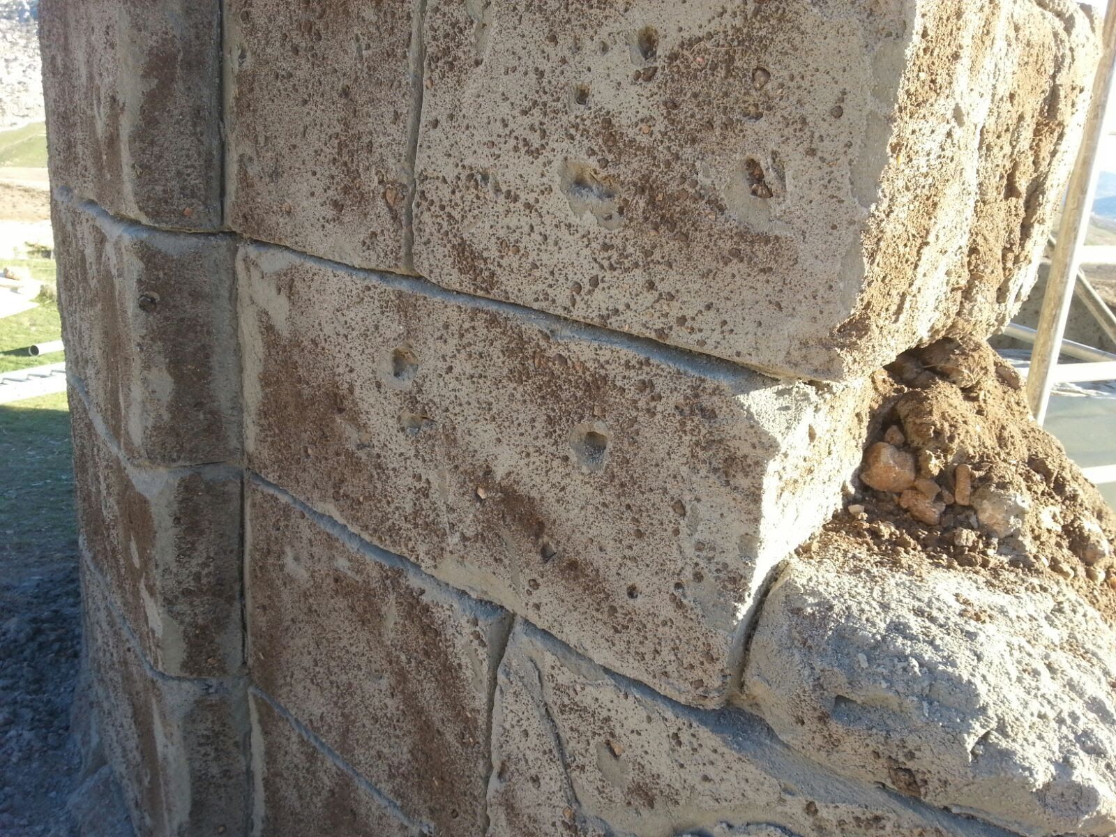 Un primer plano de una pared de ladrillos con un agujero en ella.