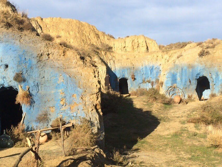 Un grupo de cuevas pintadas de azul en la ladera de una colina
