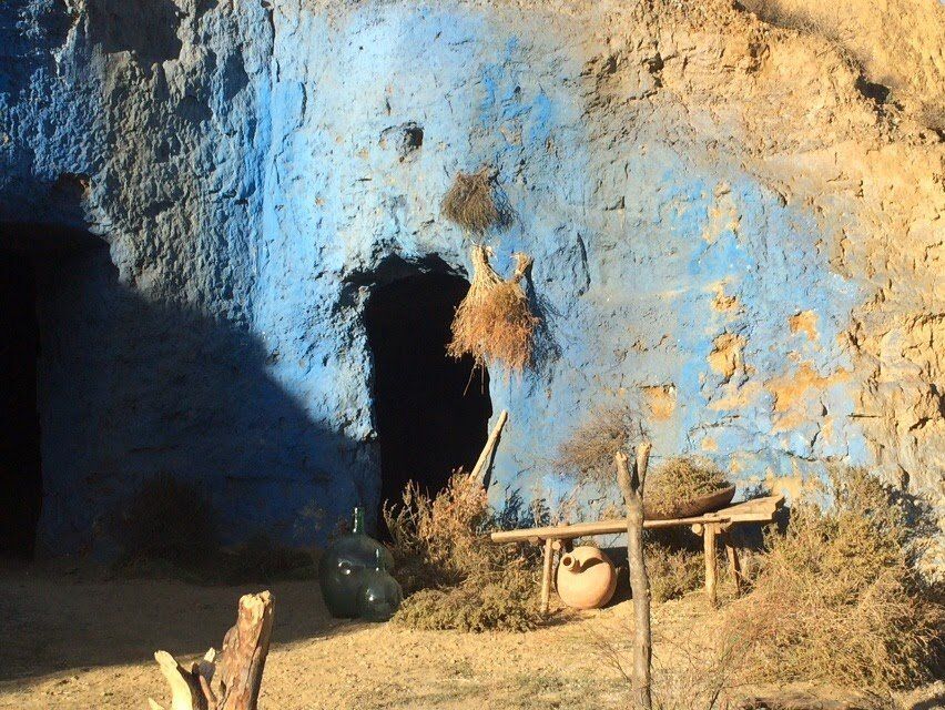 Una cueva con una pared azul y una botella delante de ella.