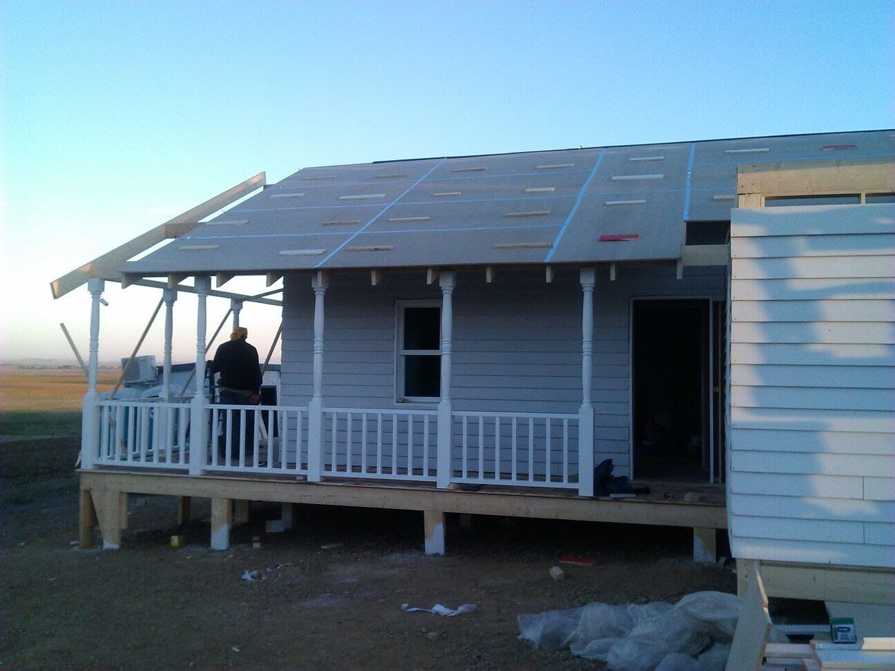 Una casa blanca con porche está en construcción