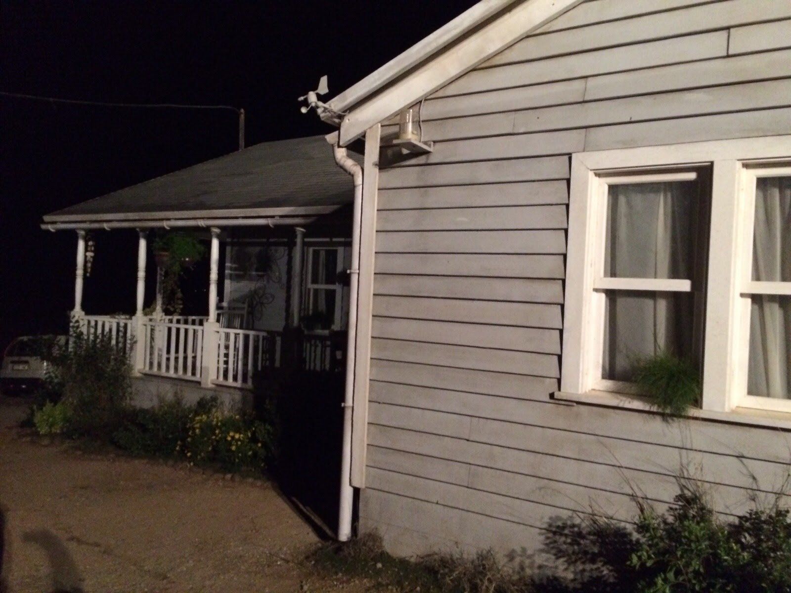 Una casa con porche está iluminada por la noche.