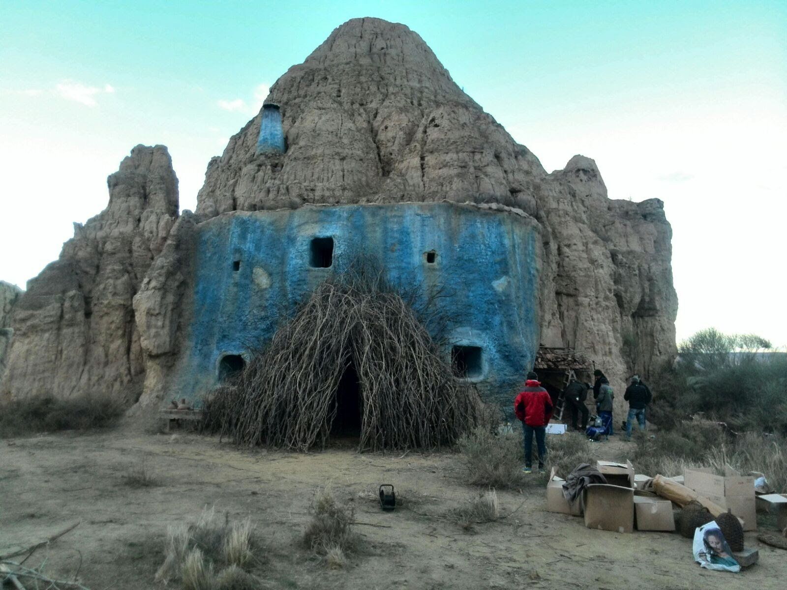Un grupo de personas de pie frente a un edificio azul.