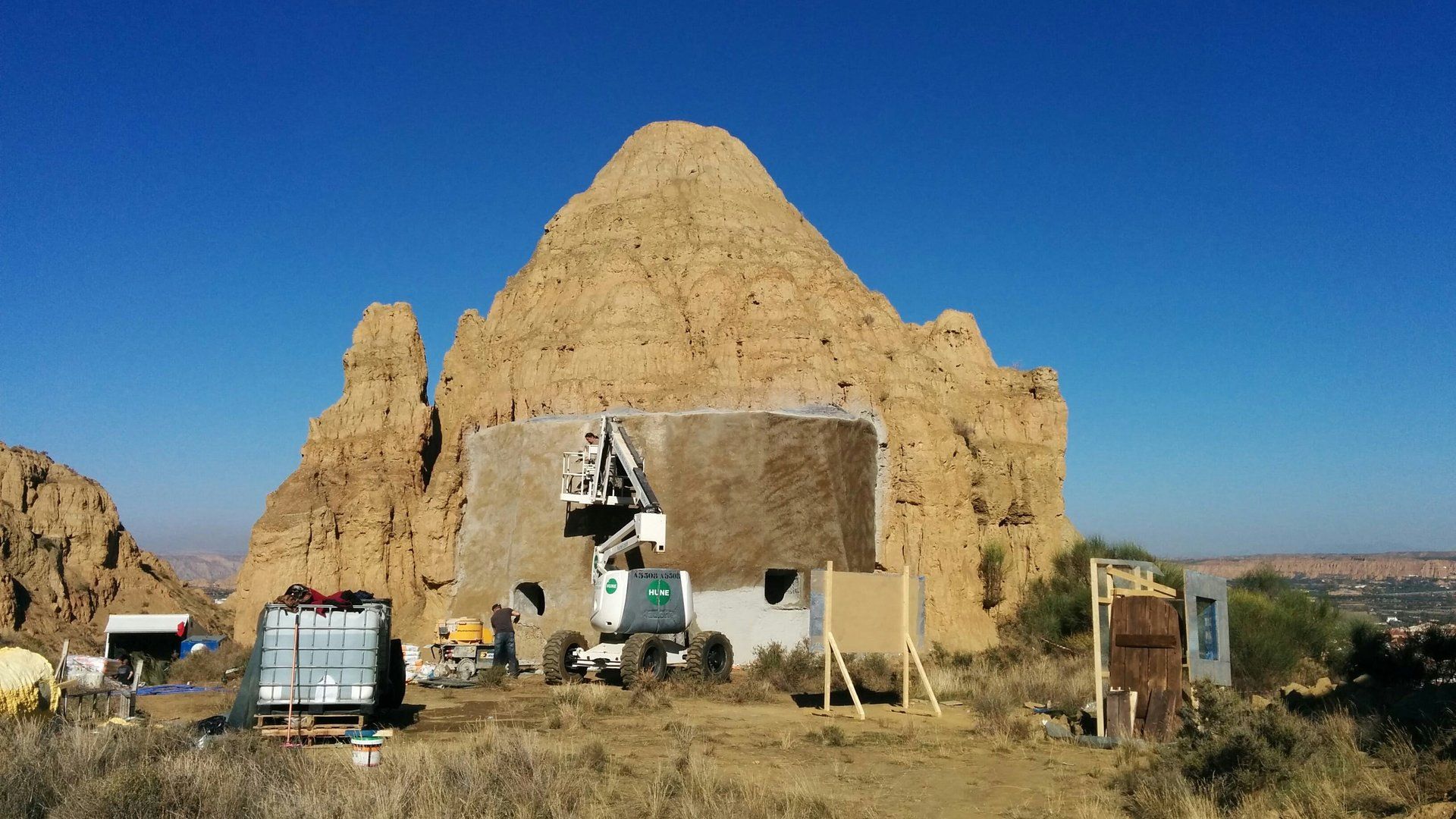 Un camión está estacionado frente a una gran formación rocosa.