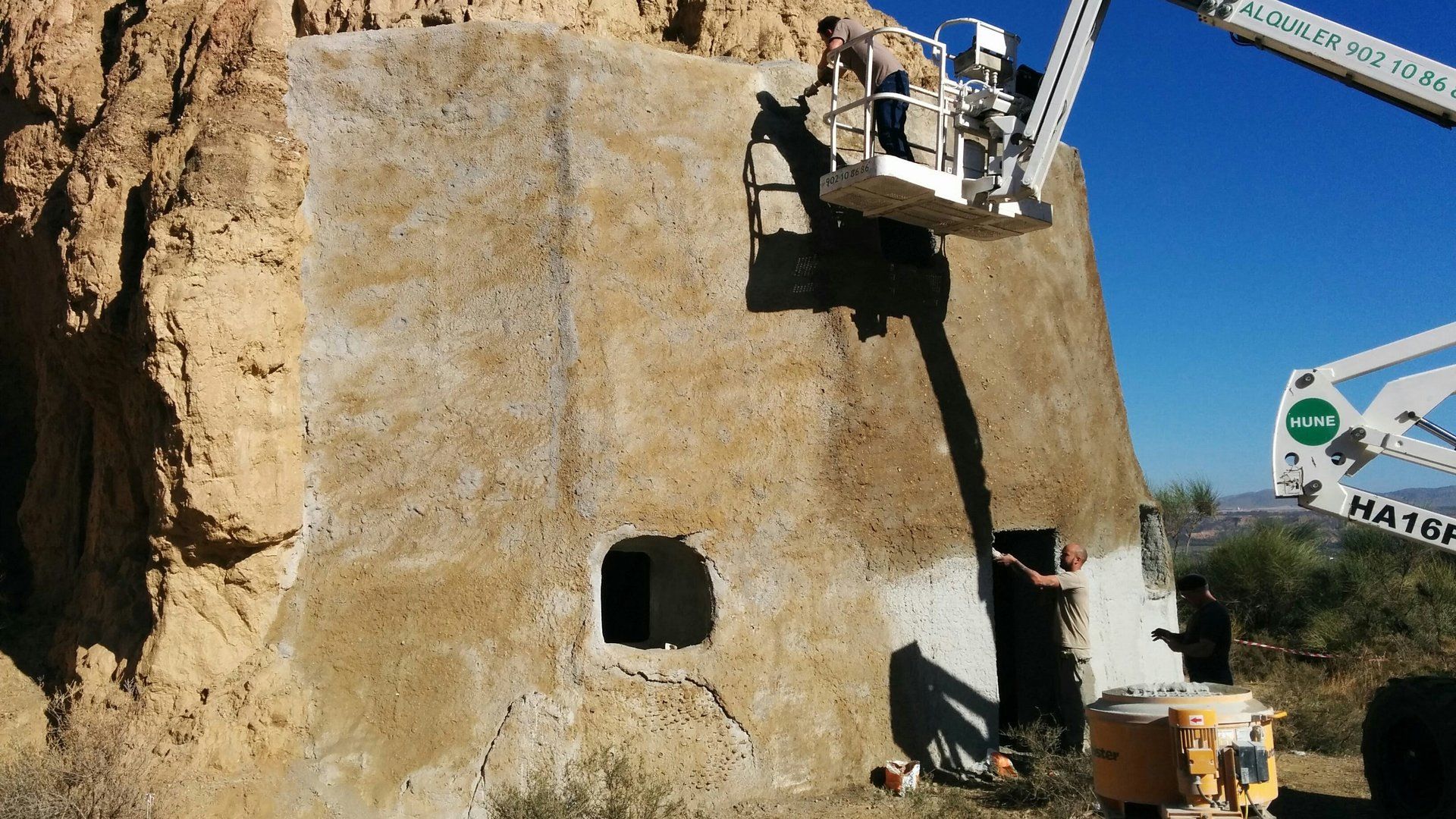 Un hombre en una grúa está pintando una pared